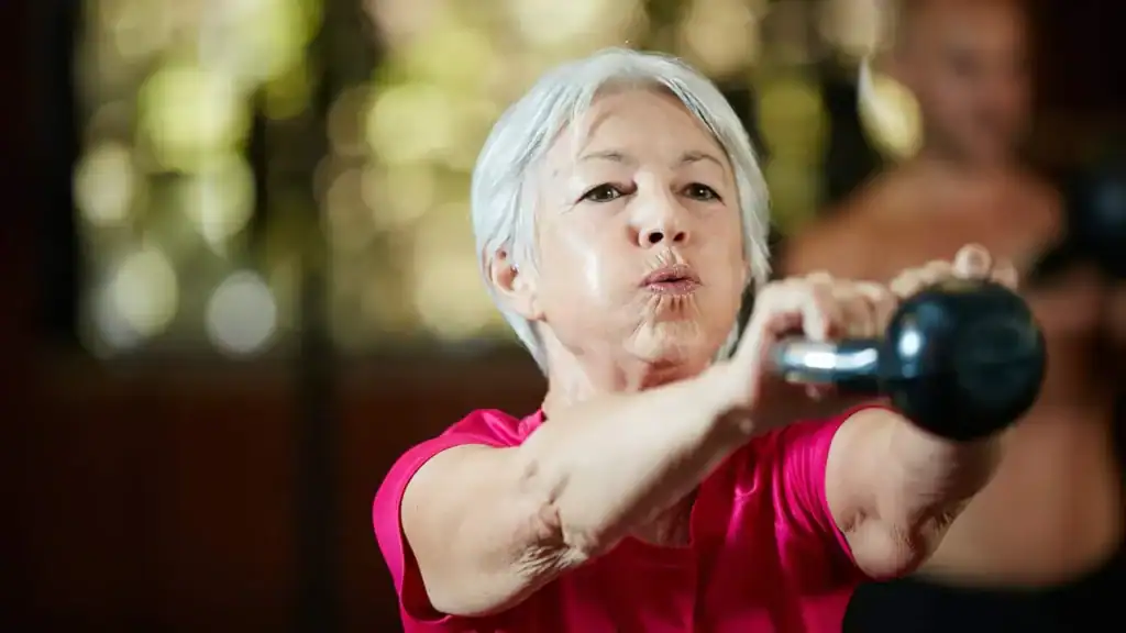 Toning Arms After 60: Empowering Womens Fitness Through Effective Weight Training 1 Older woman doing weight training Cheshire to help her strength and longevity