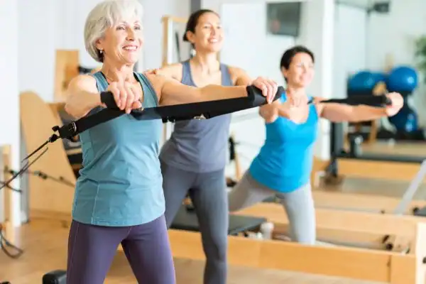 Toning Arms After 60: Empowering Womens Fitness Through Effective Weight Training 2 older woman doing weight training Cheshire and resistance in the gym to tone upper arms