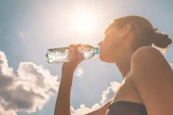 Hydration: The Secret Ingredient for a Toned Stomach and Enhanced Fitness 3 Image of woman drinking water to hydrate Cheshire after run.